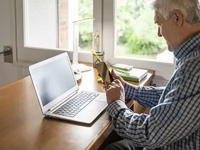 man looking at phone and computer